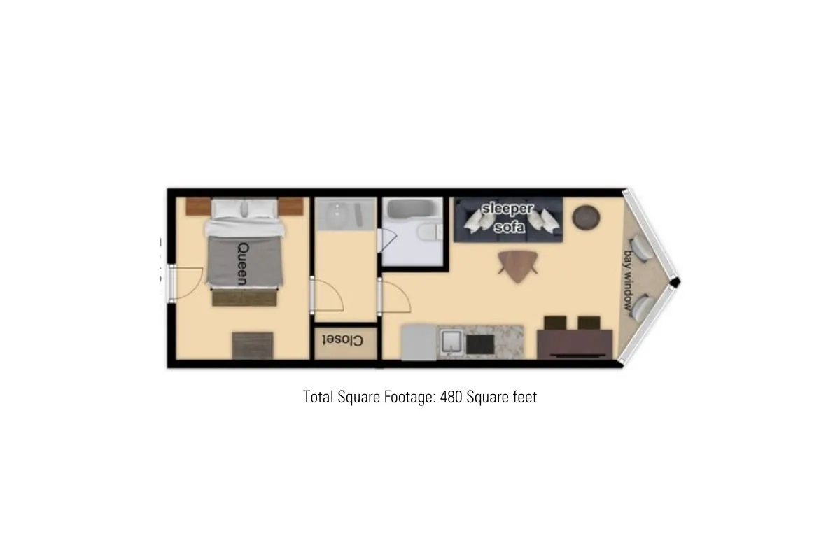 A versatile interior space that includes a queen bed, a sleeper sofa, and a kitchen area in the background. The room is laid out for both rest and flexibility, suitable for families or groups.