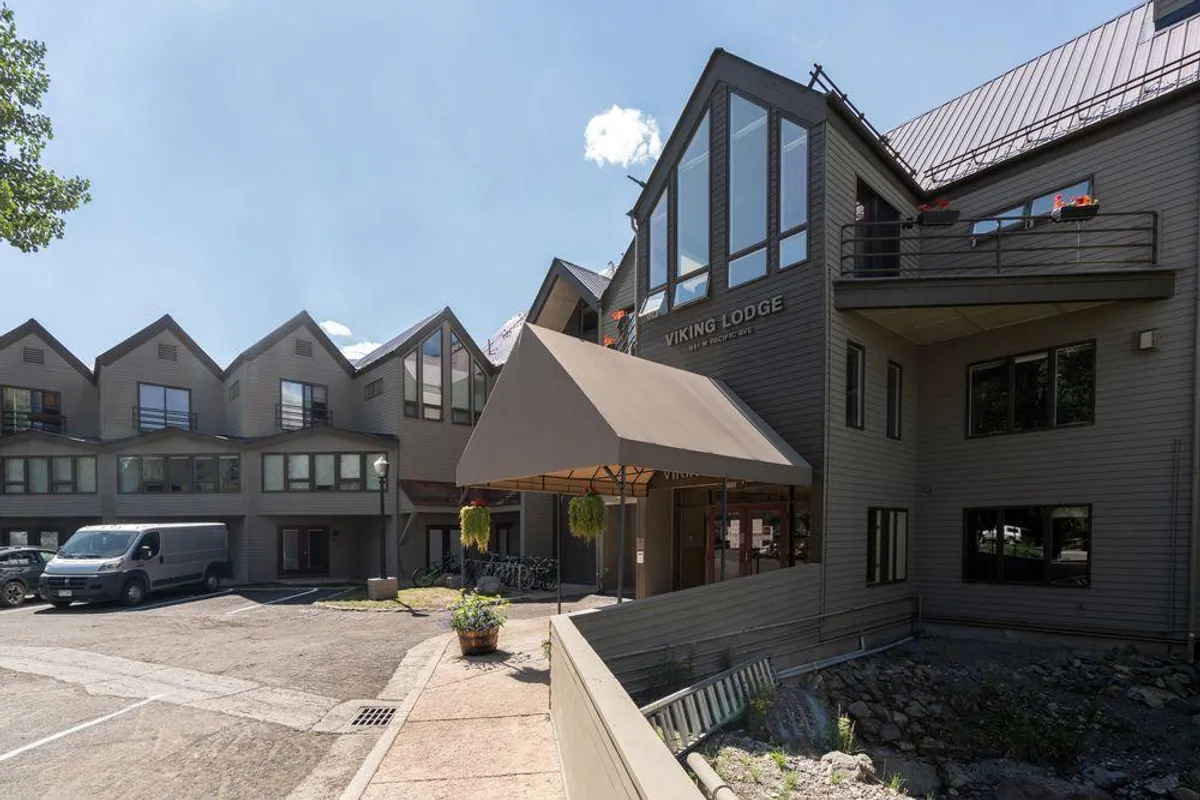 The entrance to Viking Lodge is displayed with a welcoming sign, entry awning, bicycle rack, and a landscaped area, creating a friendly first impression of the property. The setting is approachable and family-oriented.